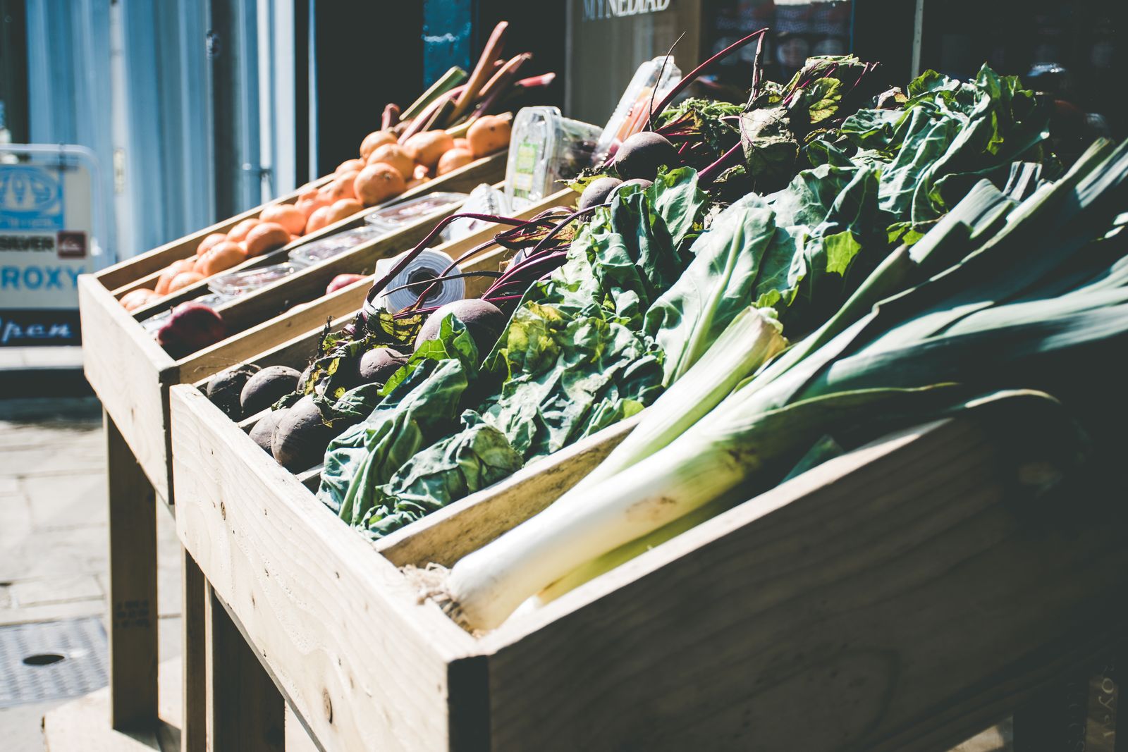 Leeks, chard and greens stacked in wooden crates on a shop display