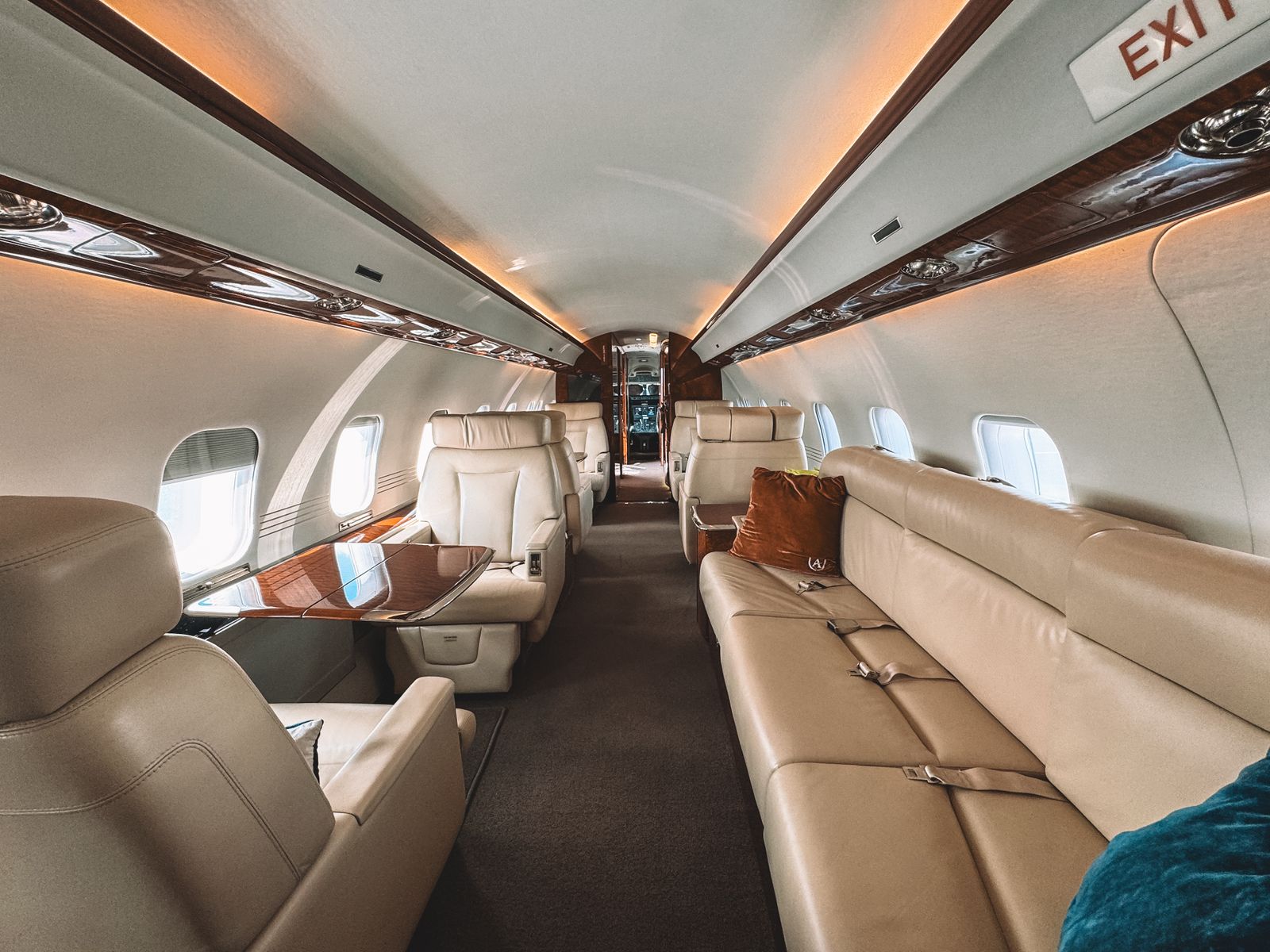 Leather club seats and a long sofa in a private jet cabin