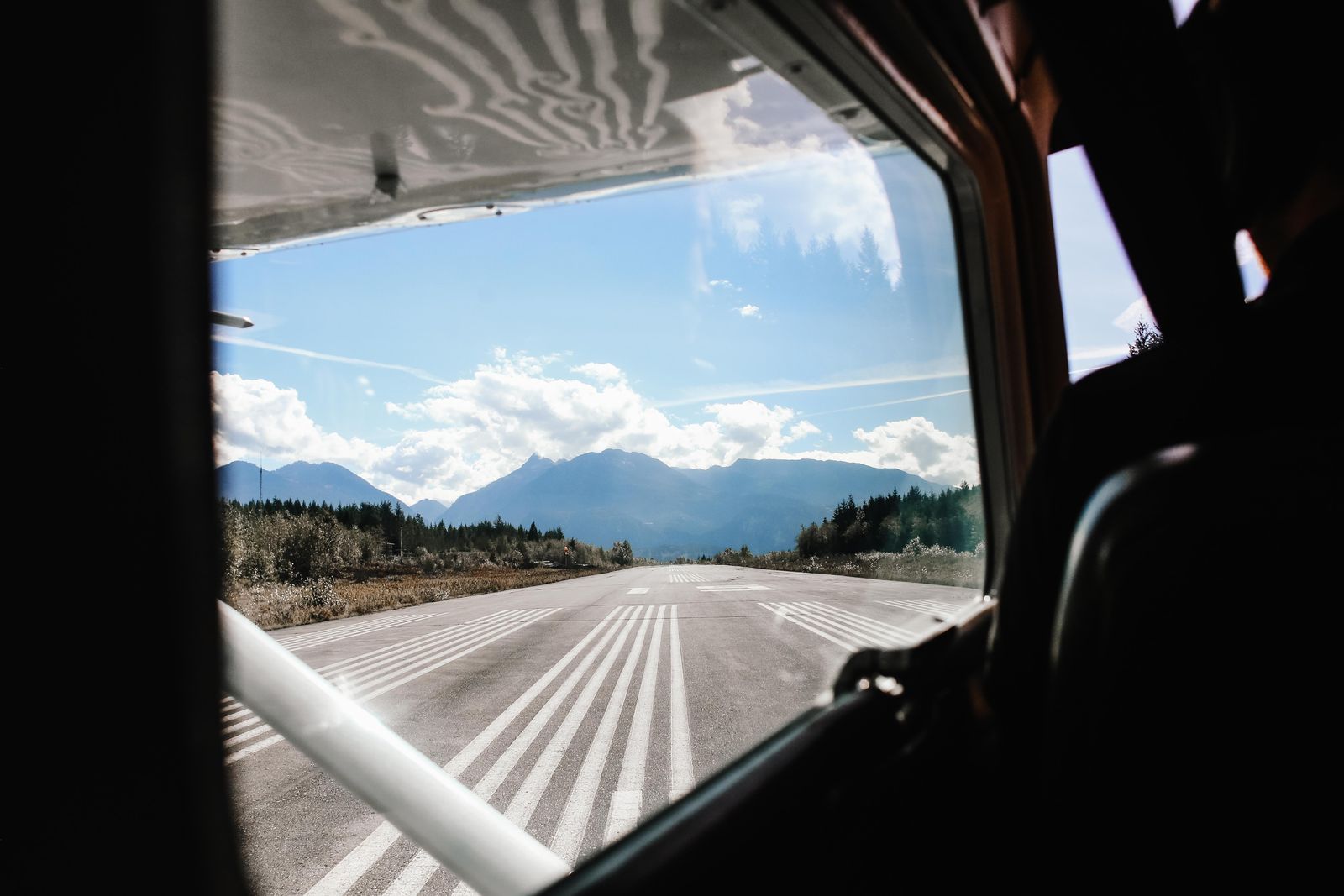 A mountain runway seen through the windscreen of a small aircraft