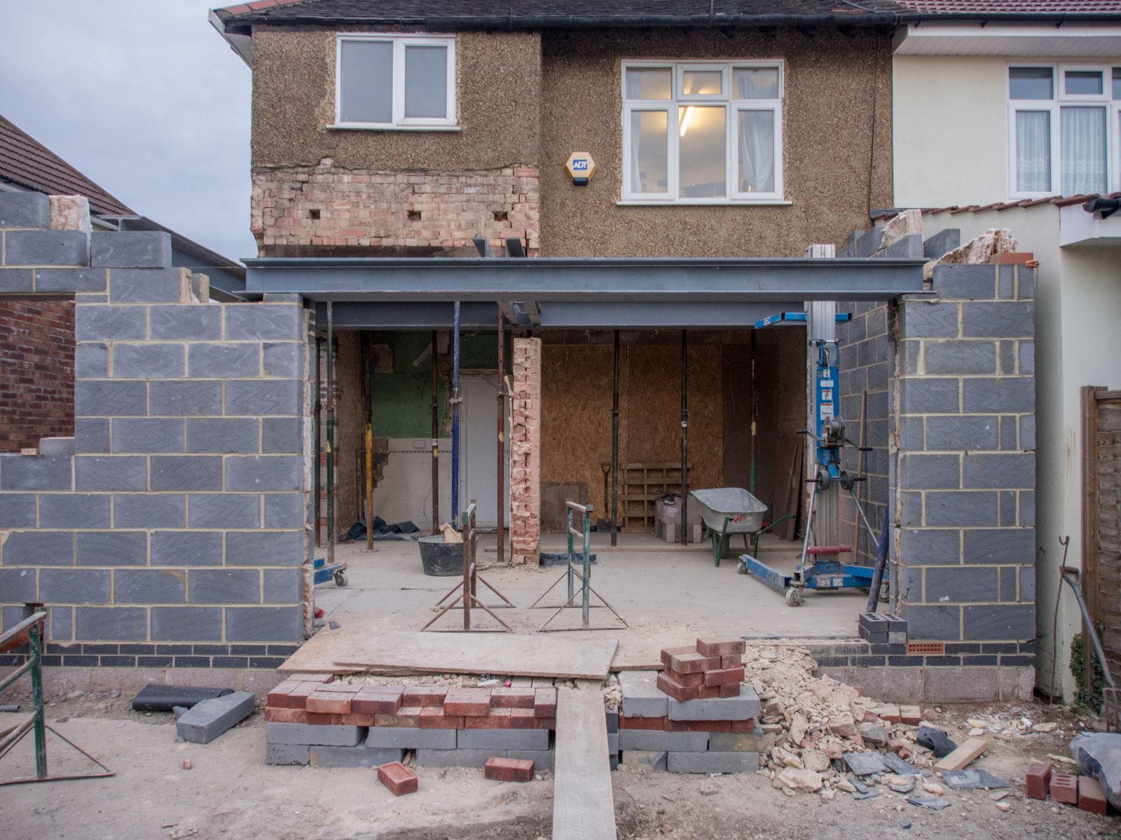 Rear extension under construction on a brick house, with block walls and a steel frame