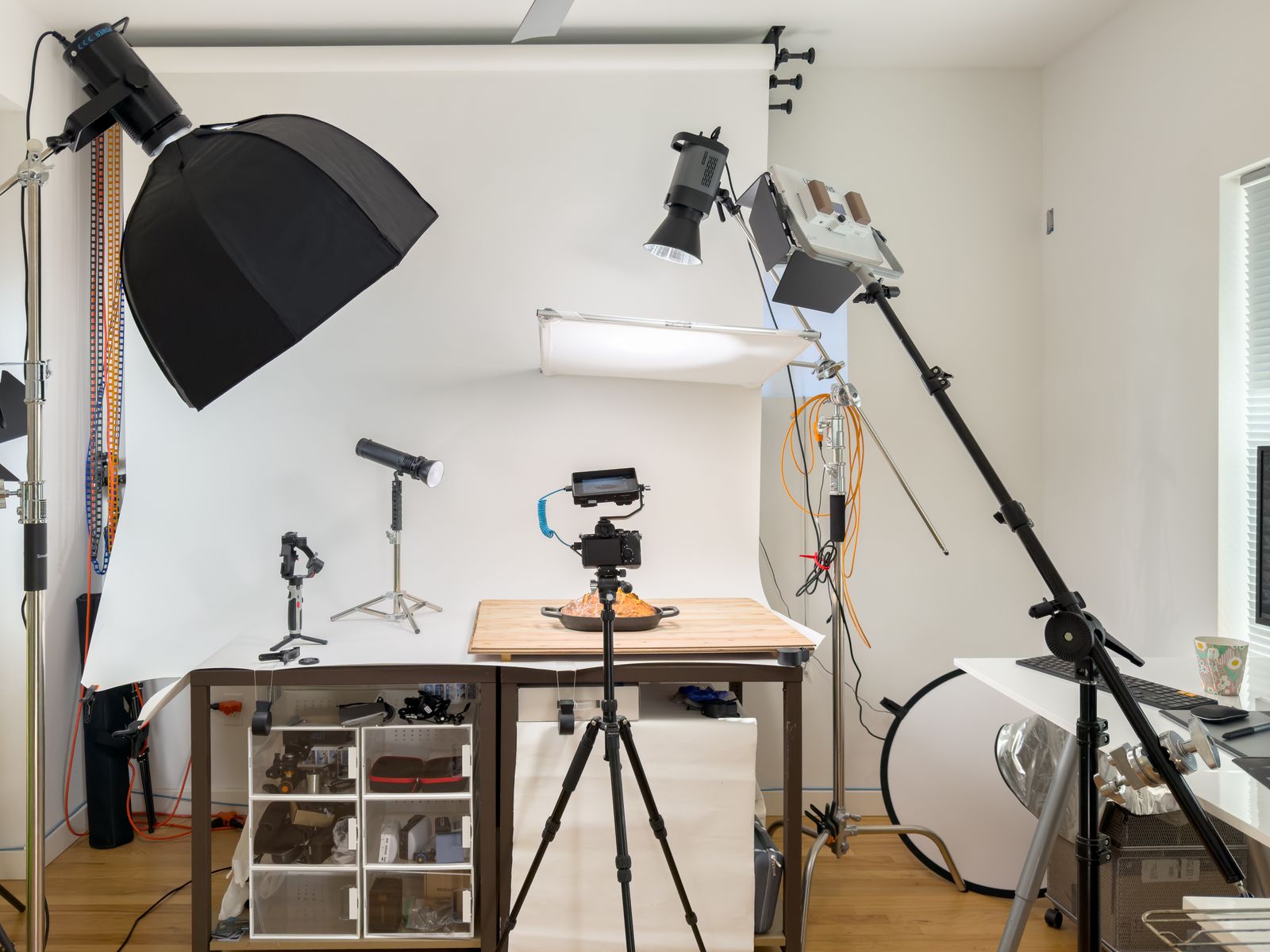 Product photography setup with a table, camera on a tripod and softboxes