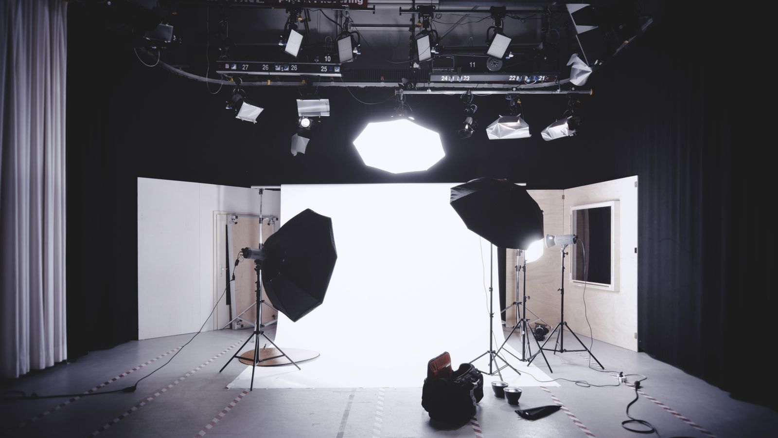 White cyclorama studio with softboxes and overhead lights ready for a shoot