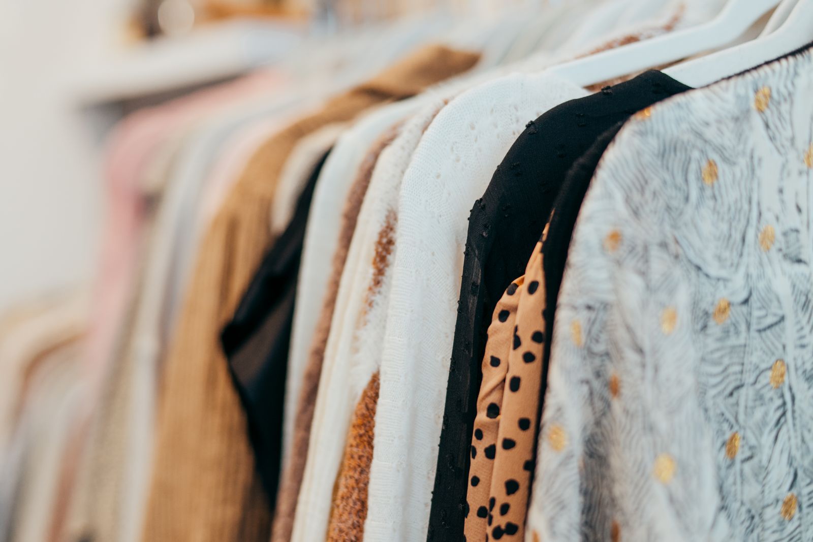 Patterned children's shirts and dresses on a shop rail