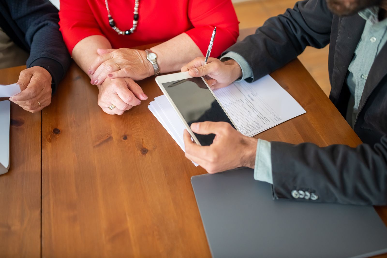 An adviser and a business owner going through documents at a wooden table