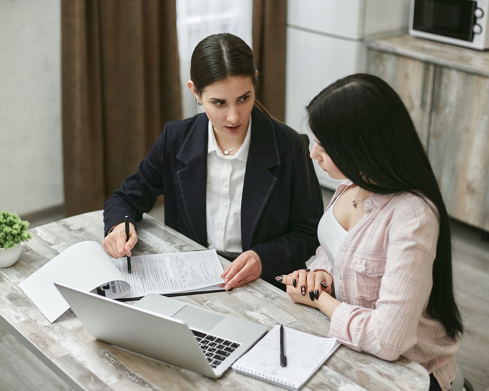 Two colleagues going through a contract together at an office desk
