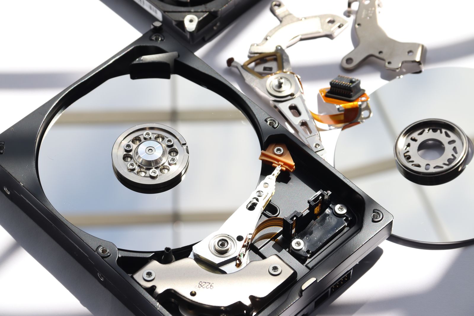 The inside of an opened hard drive: platter, arm and magnets