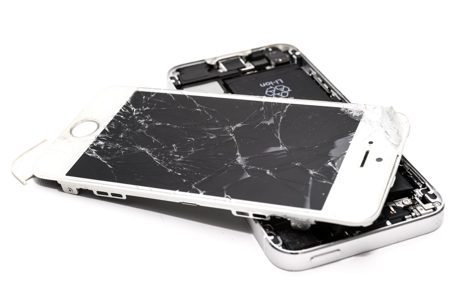 Two phones with shattered screens lying on top of each other
