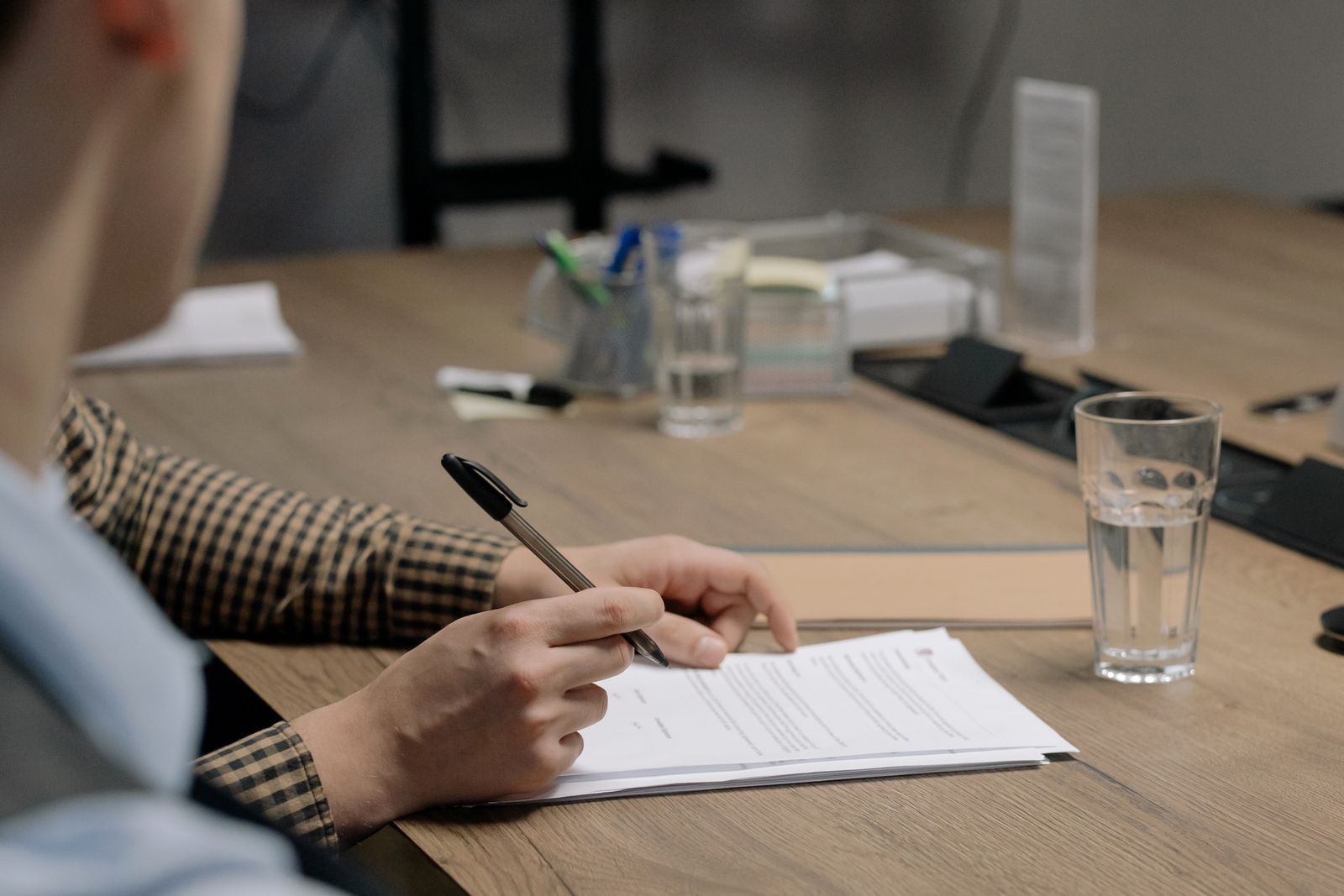 A director signing a document at a wooden table