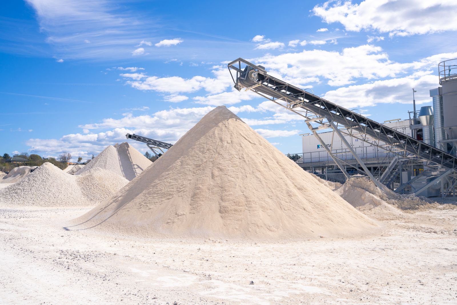 Sand and gravel piles under a conveyor at a quarry