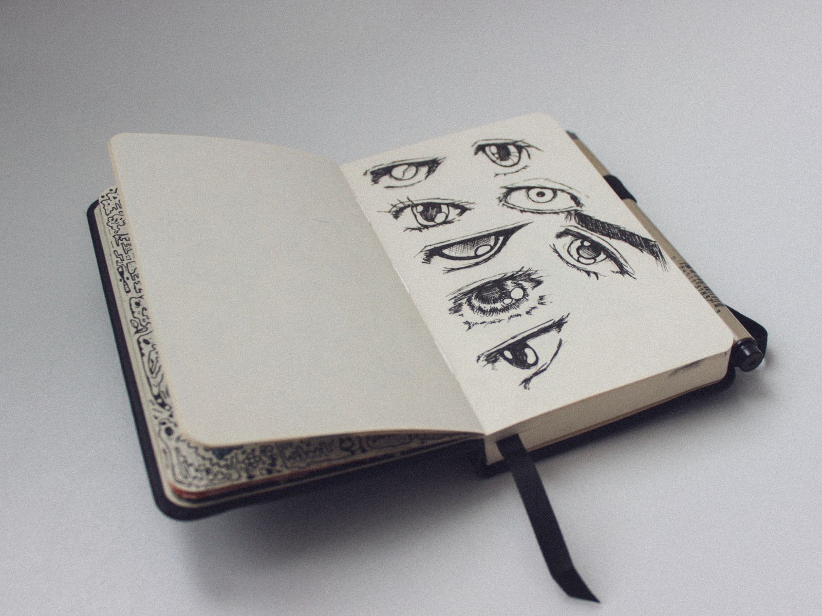 An open sketchbook with pencil studies of eyes