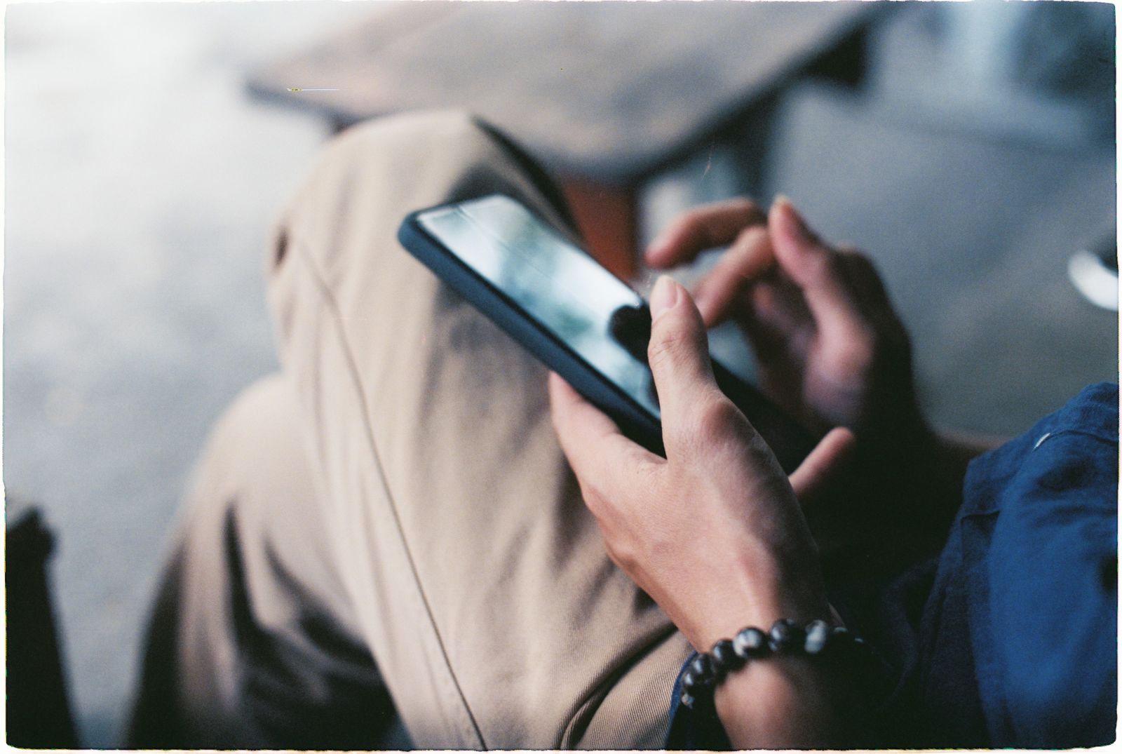 Hands holding a smartphone and scrolling a social feed