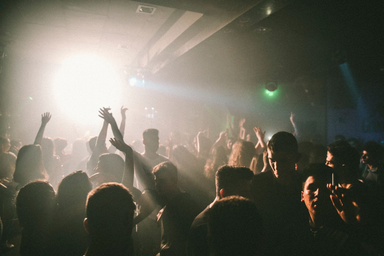 A crowd dancing under white spotlights