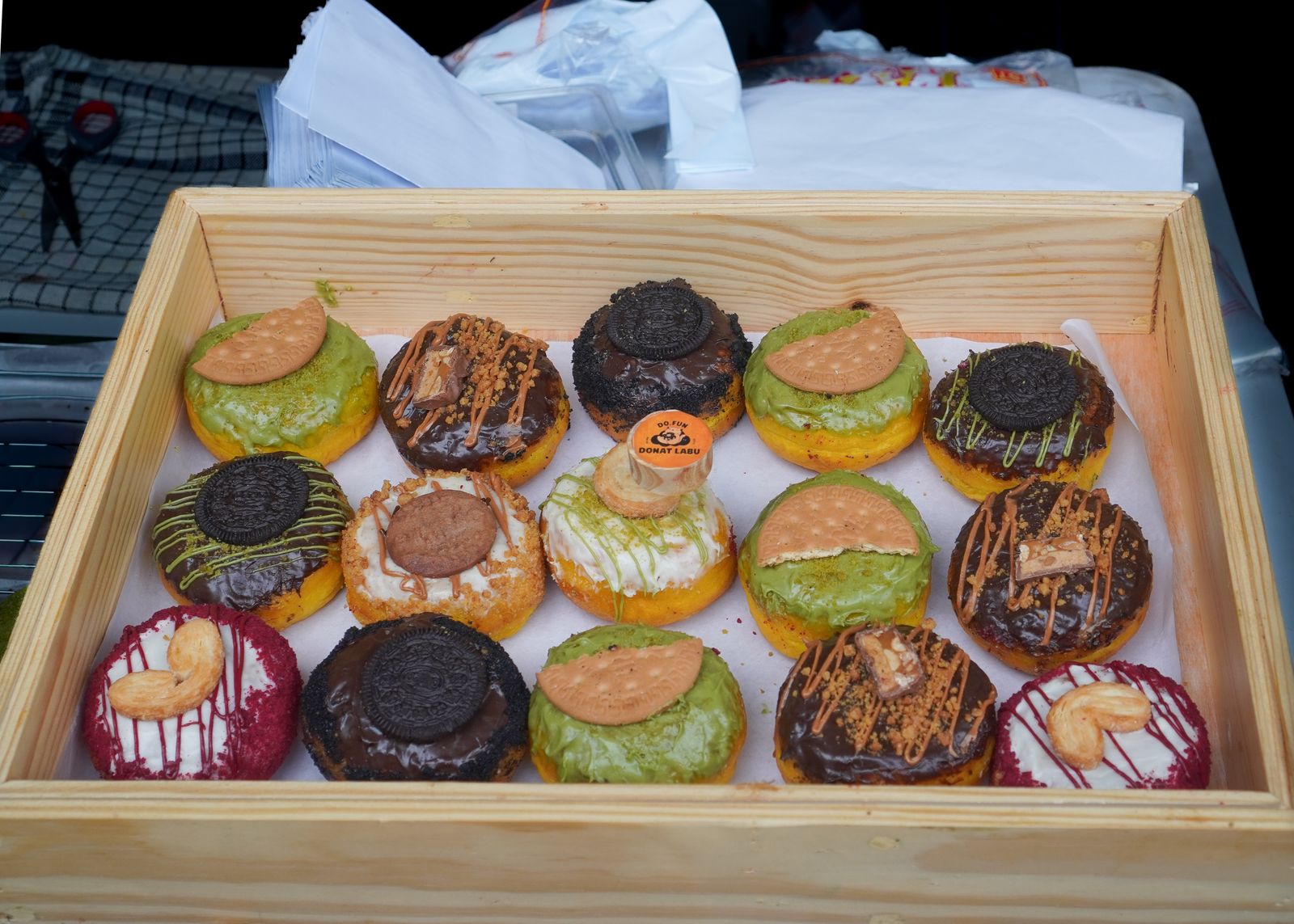 Mixed donuts with different glazes in a wooden box