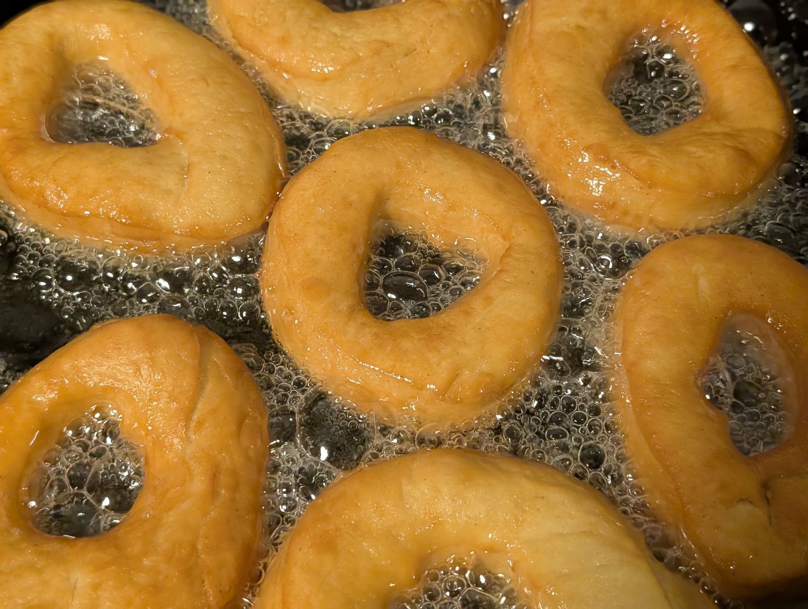 Ring donuts frying golden in hot oil