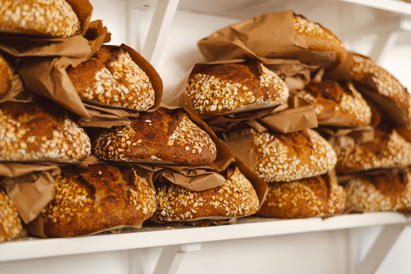 Sourdough loaves stacked on wooden bakery shelves