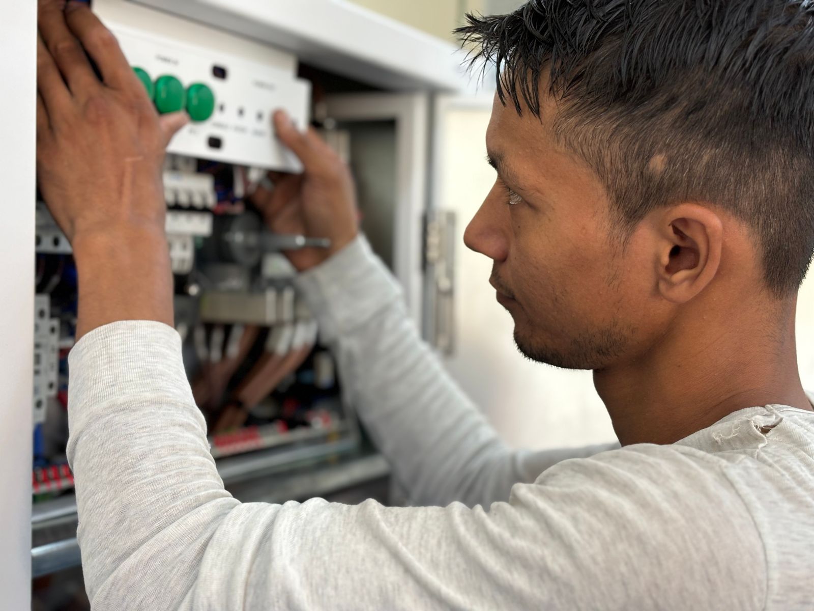 An electrician checking a breaker in an open electrical panel
