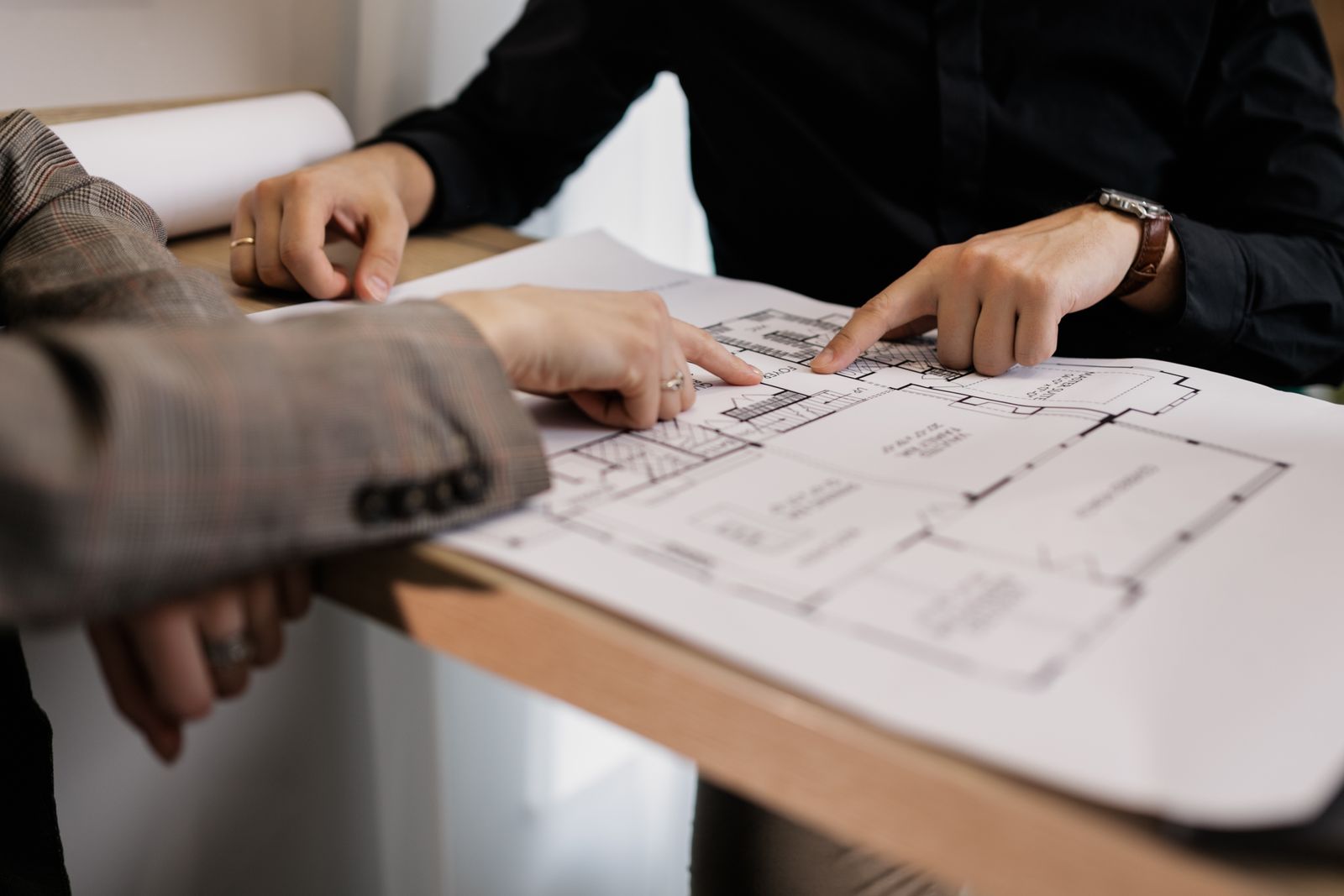 Hands pointing at a printed site plan on a desk