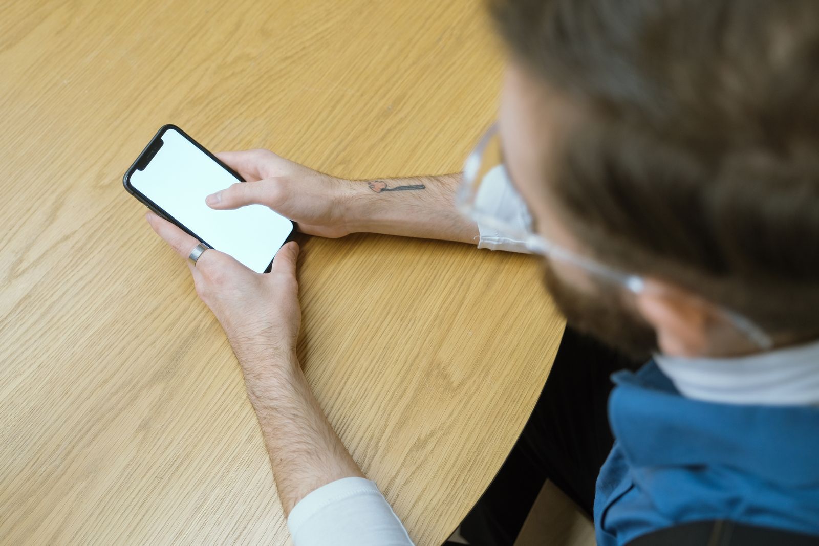 Hands holding a smartphone over a wooden table