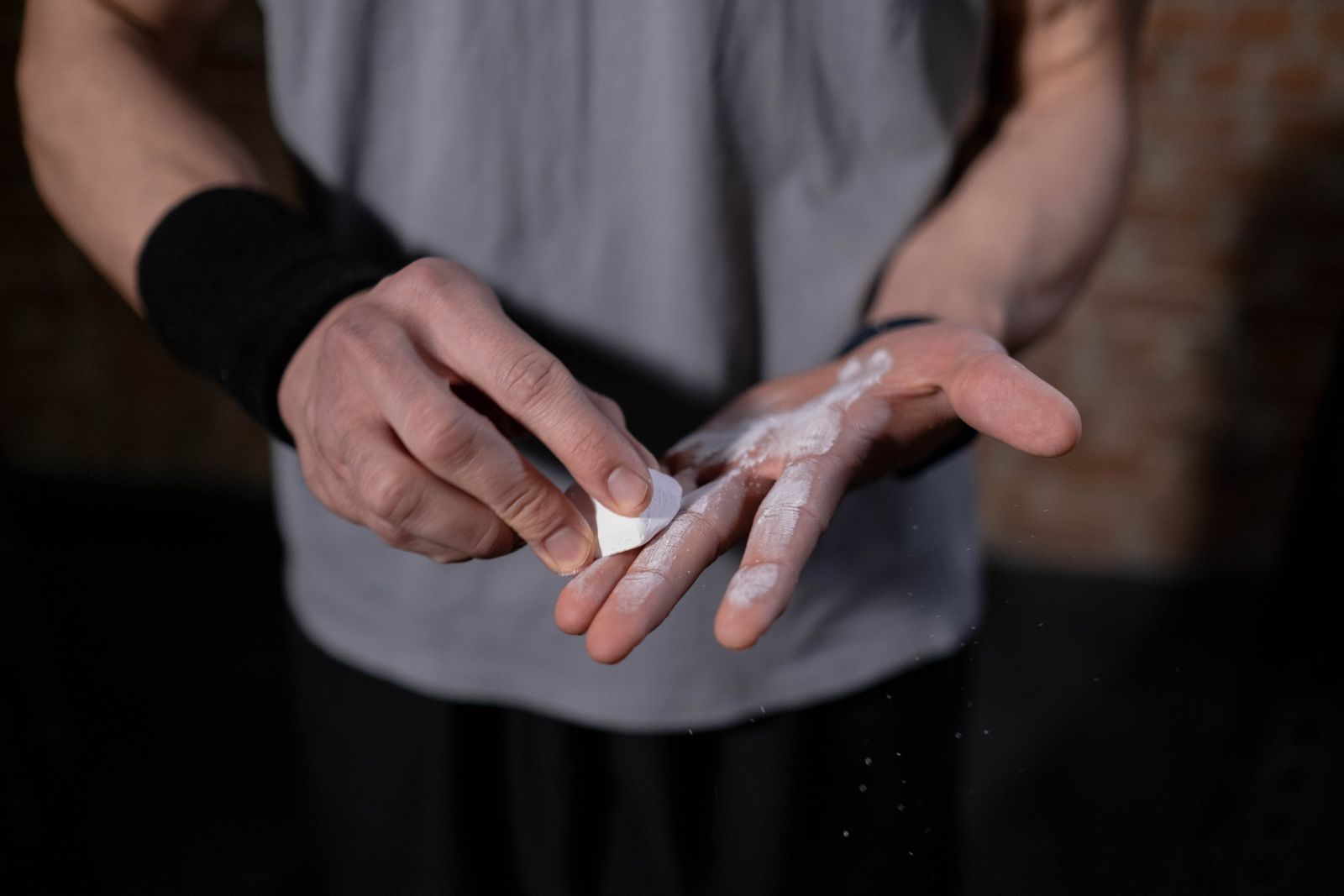 Hands rubbing a block of lifting chalk before a set
