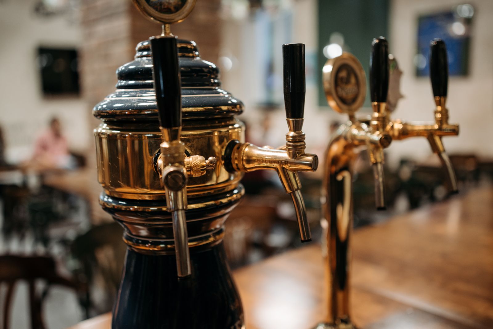 Polished beer taps on a wooden bar counter