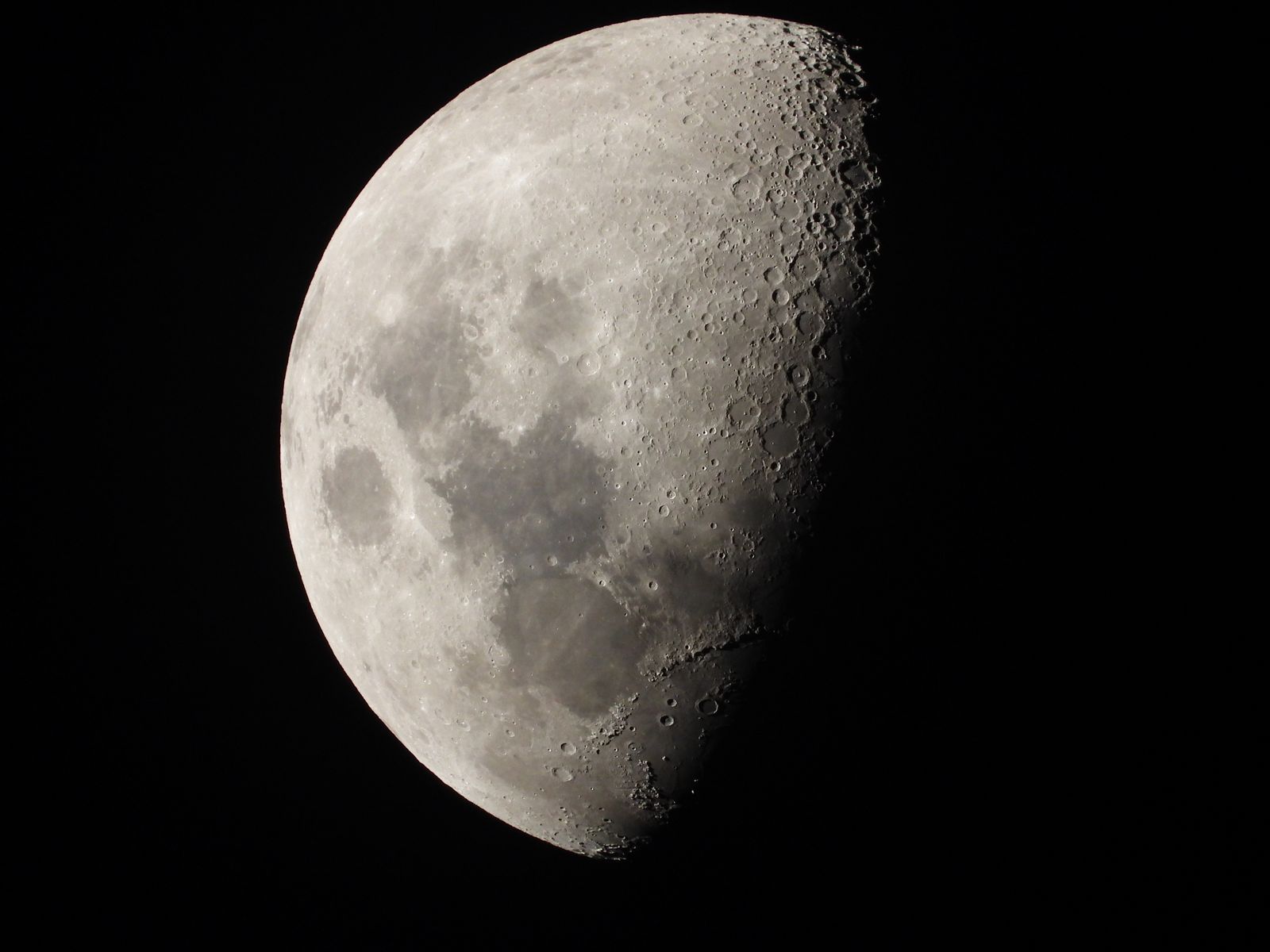 The Moon a little past first quarter, craters sharp along the line between light and shadow