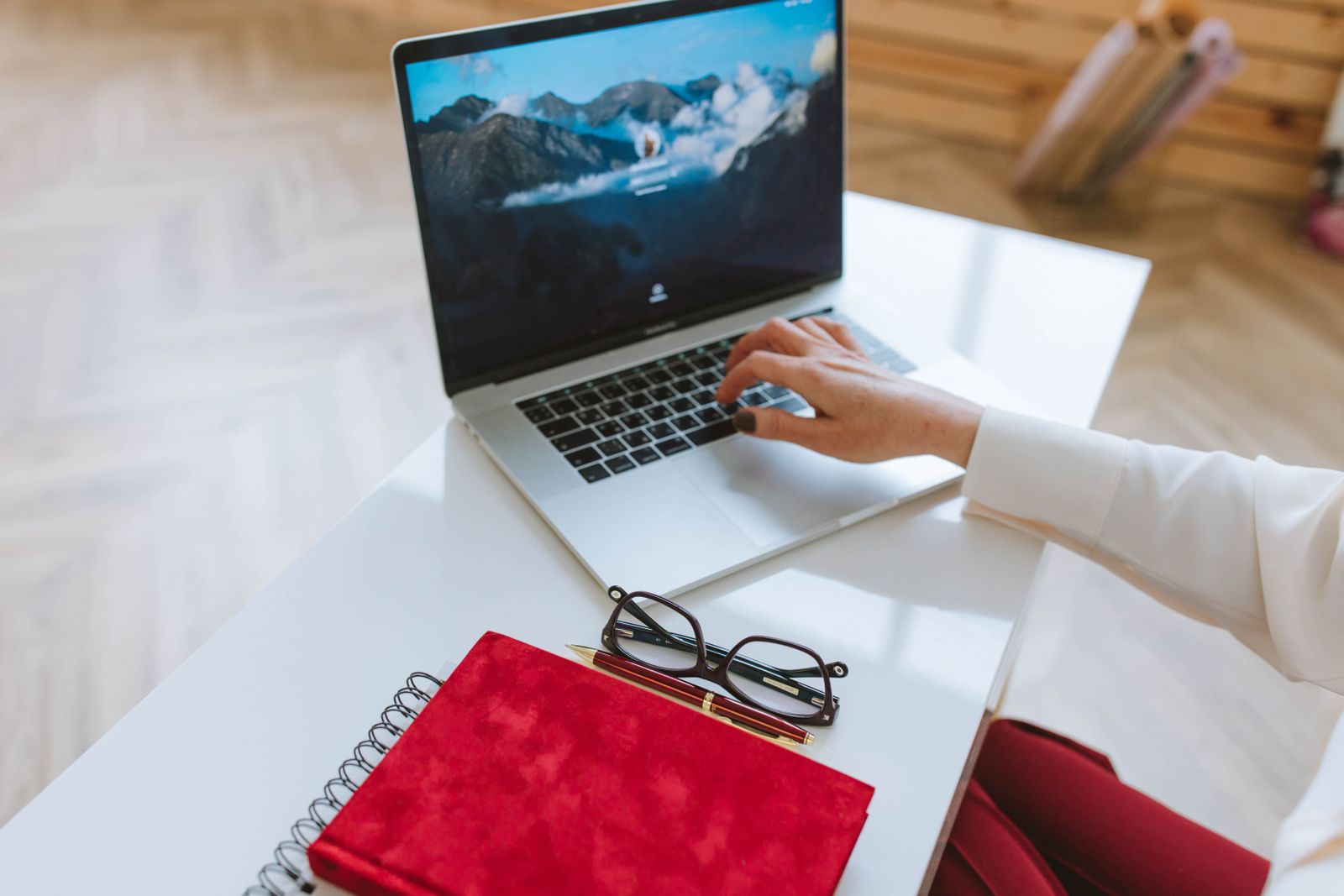 Laptop, notebook and glasses on a white table