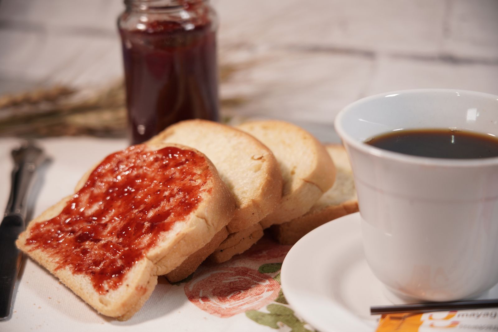 Toast with strawberry jam and a cup of black coffee