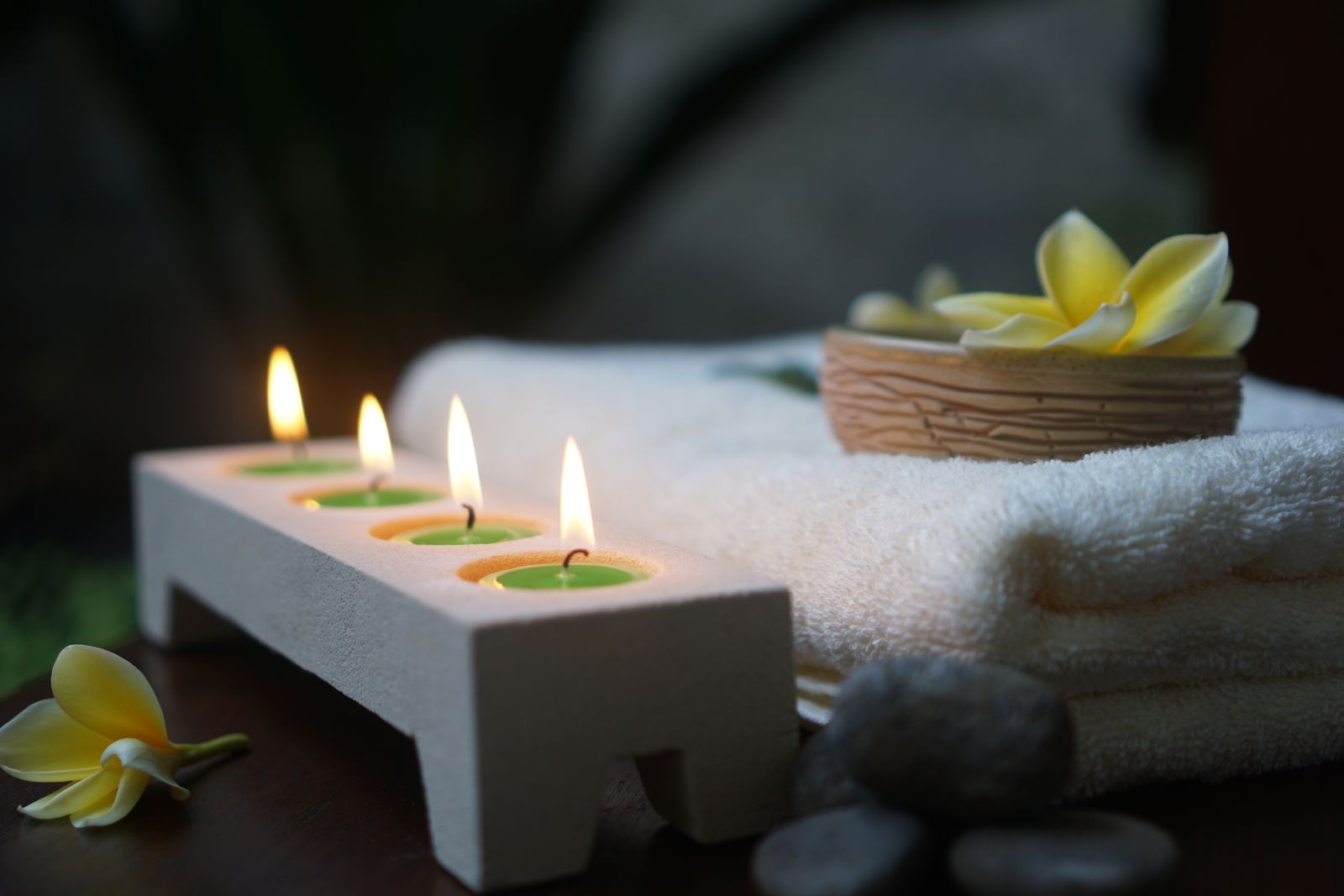 Candles, white towels and flowers in a spa room