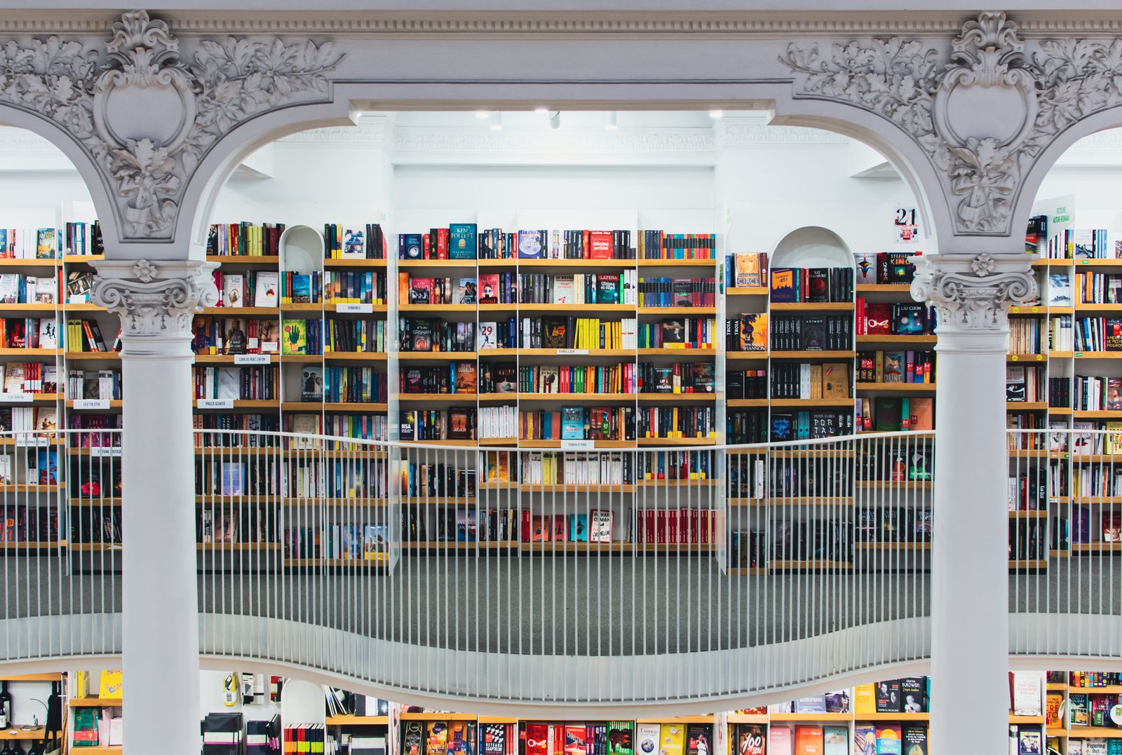 A library hall with tall bookshelves behind white columns