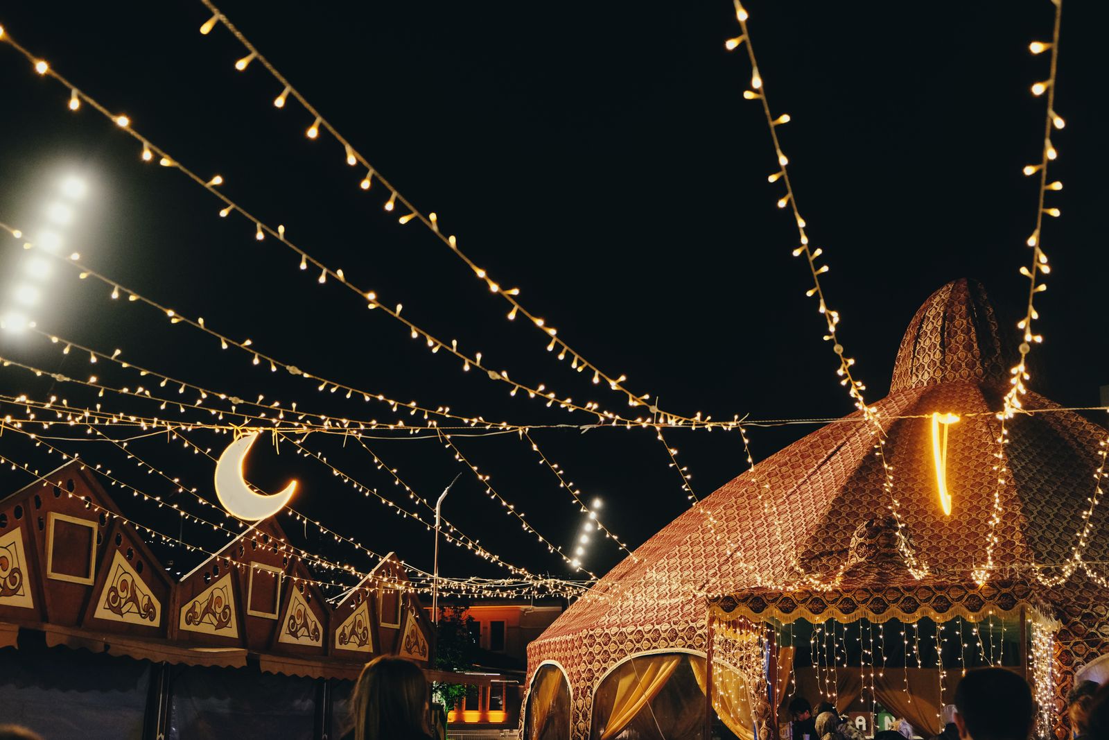 Strings of lights over festival tents at night