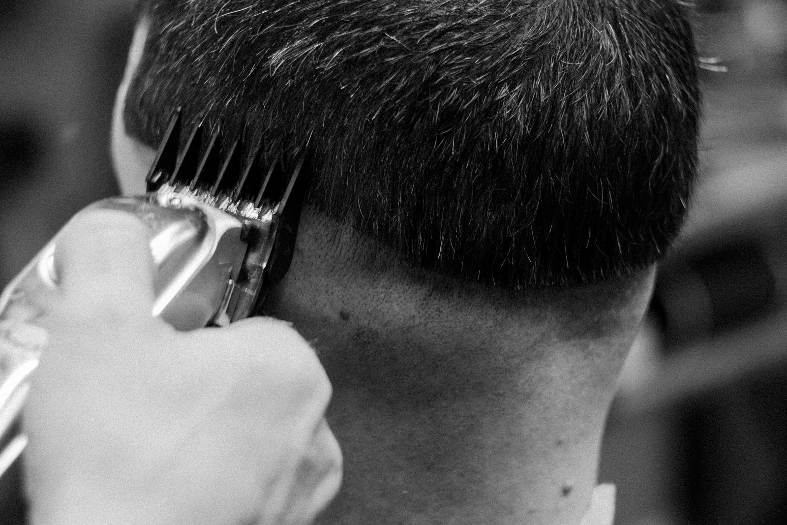 Clippers blending a fade at the back of the head, in black and white
