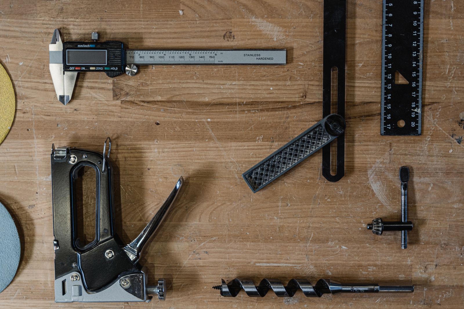 Measuring and woodworking tools laid out on a wooden surface