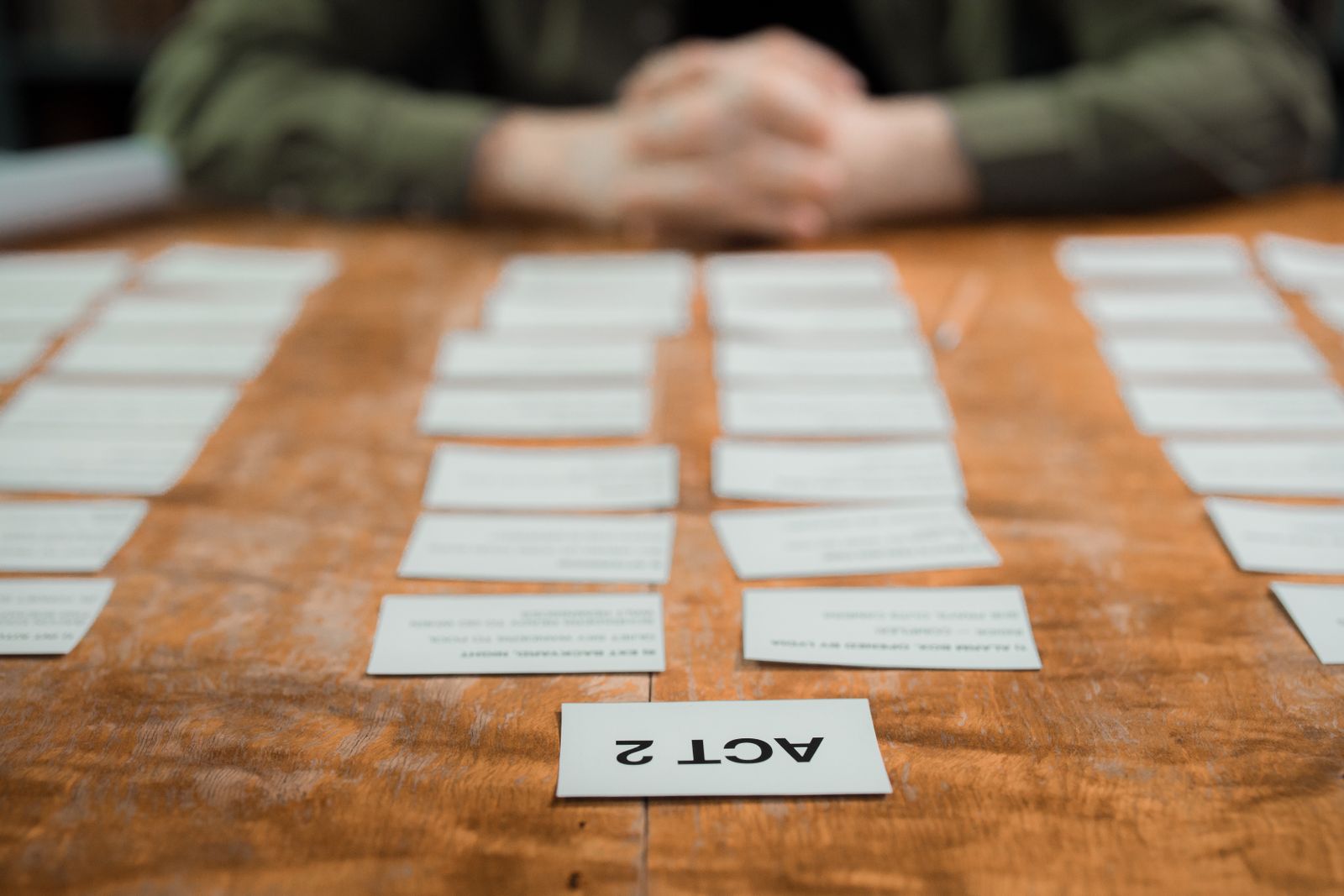 Index cards laid out in rows on a table to plan the order of scenes