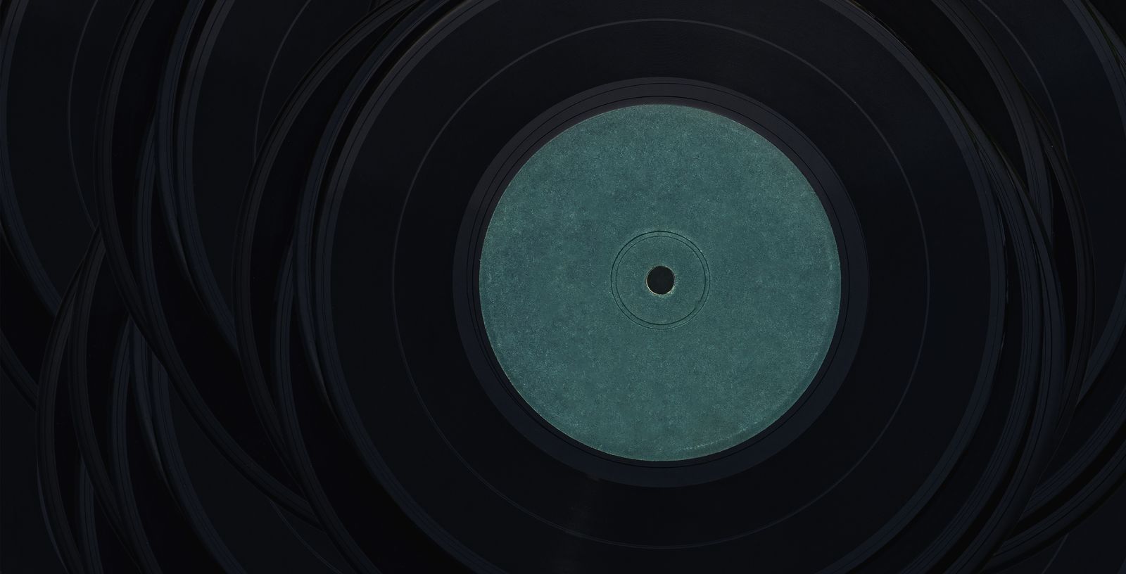 Black records overlapping, the top one with a plain blue-green centre label