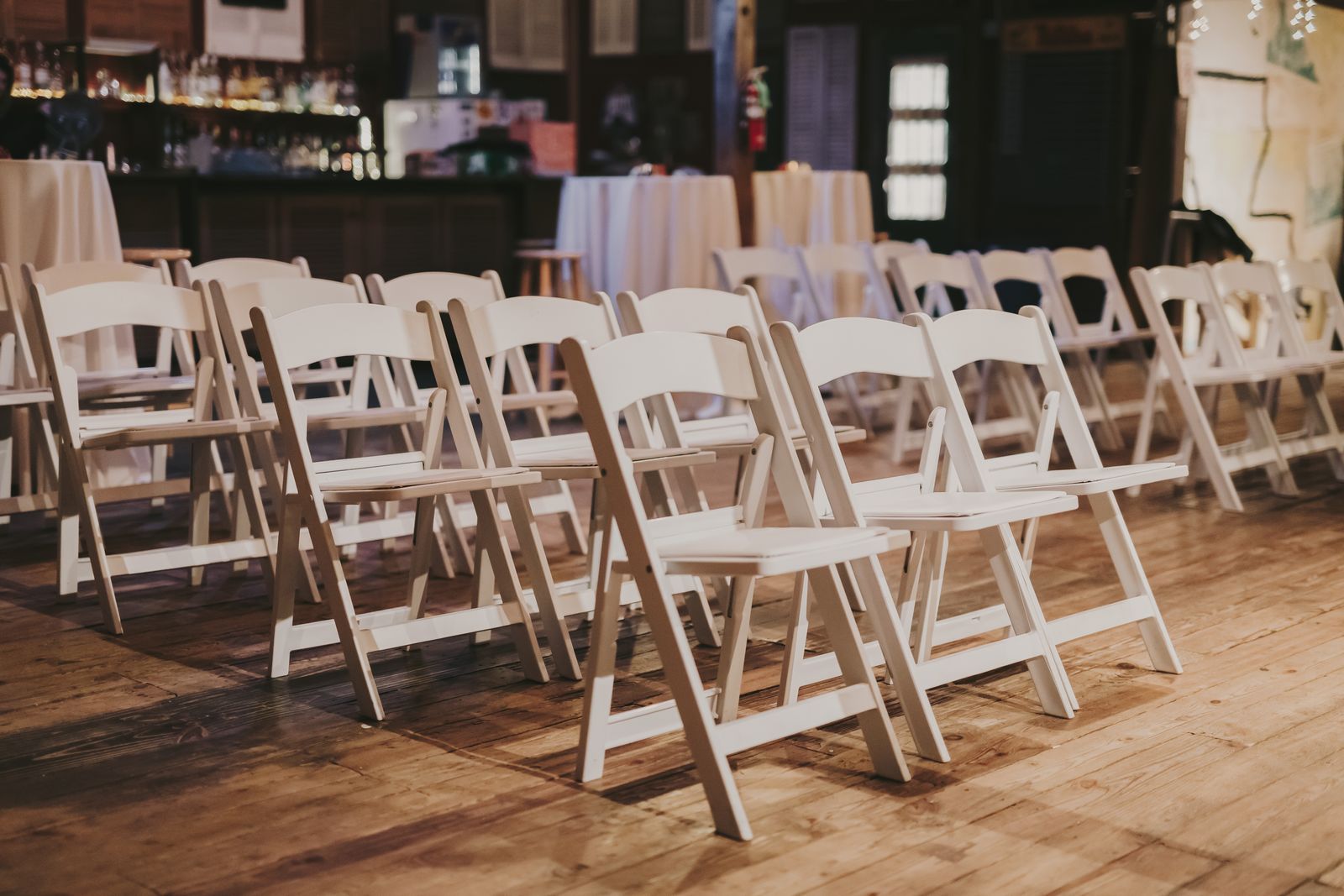White folding chairs set out in rows in a hall