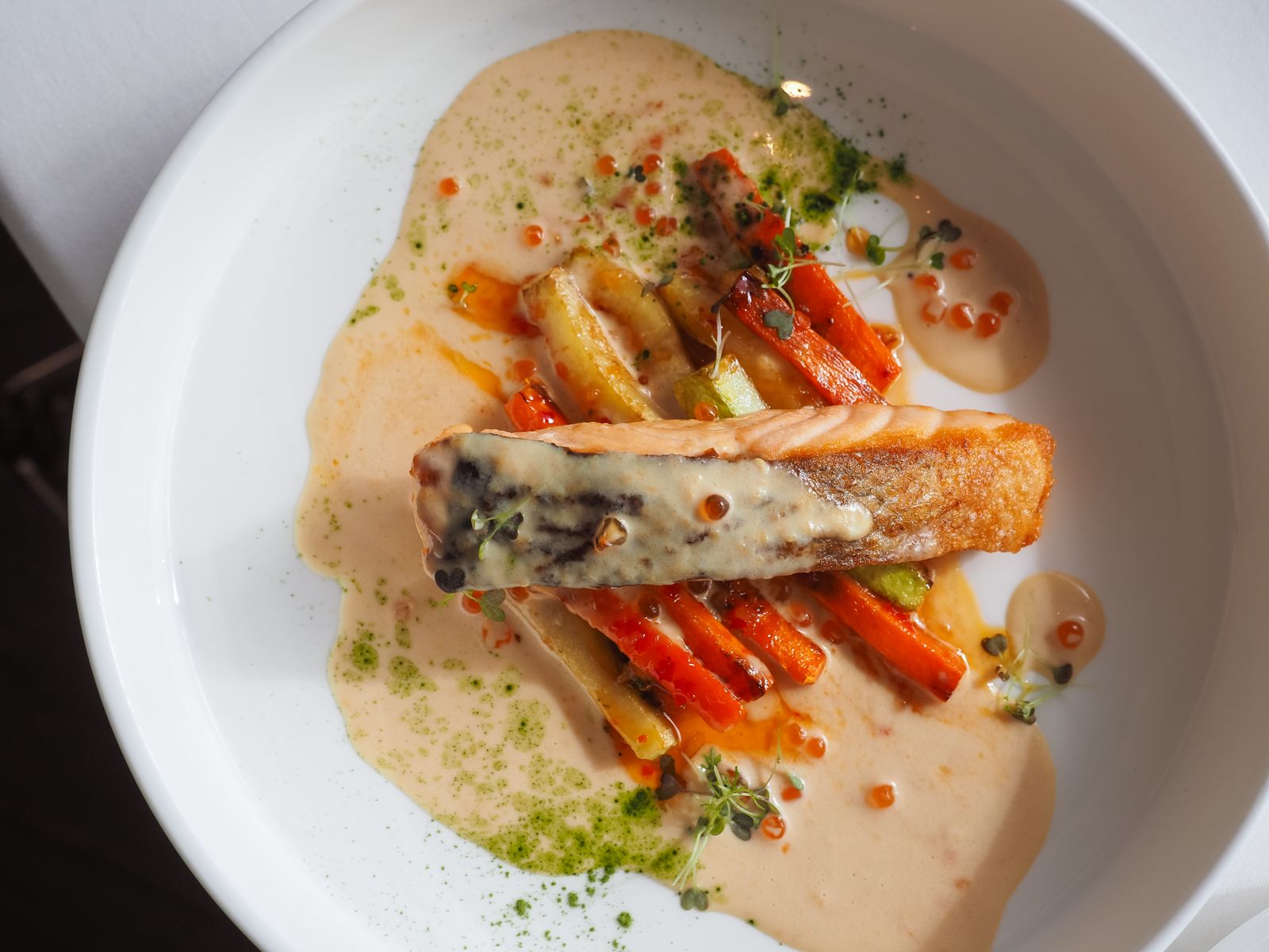Salmon fillet on glazed carrots with a creamy sauce