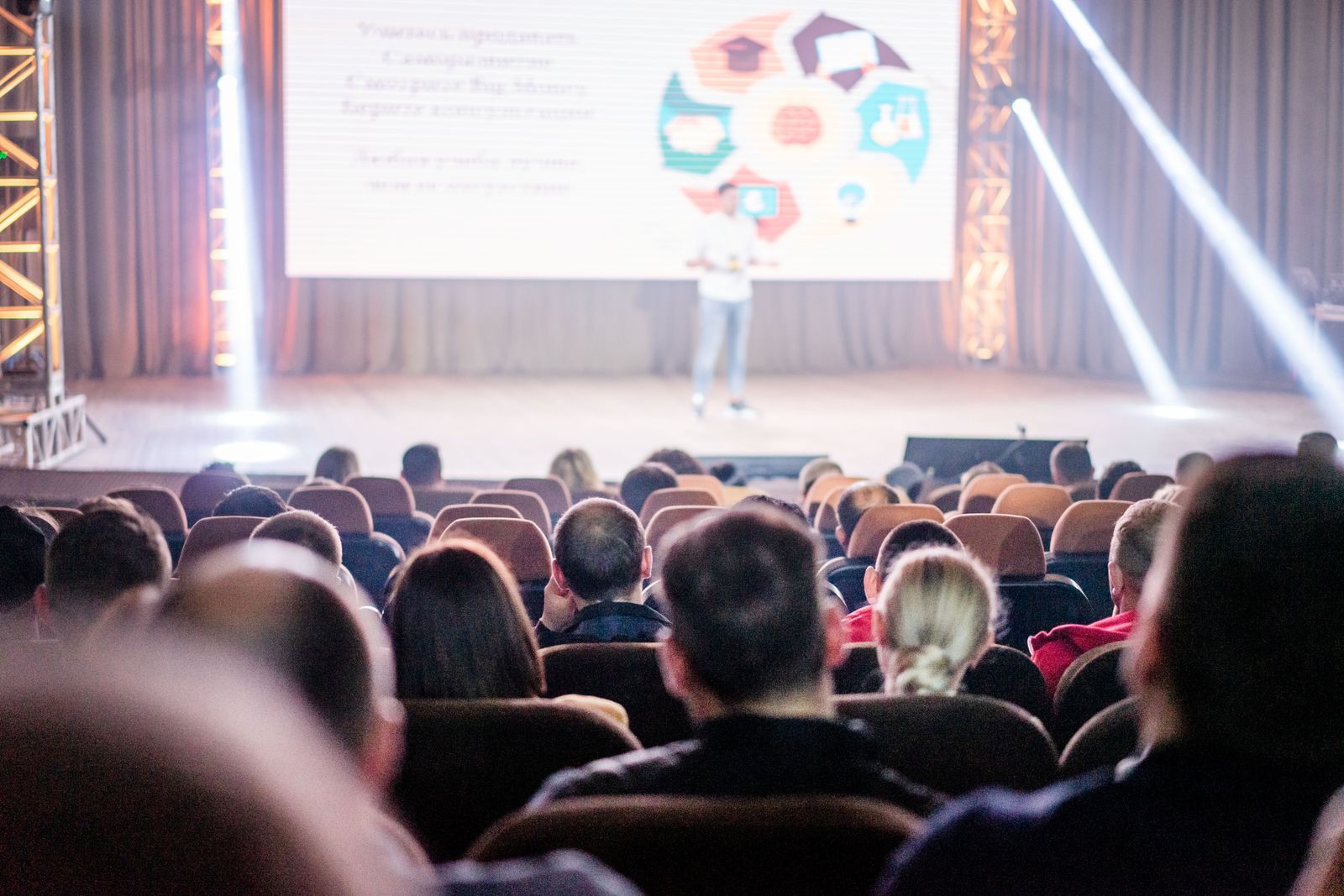 Delegates seen from behind, listening to a talk at a conference