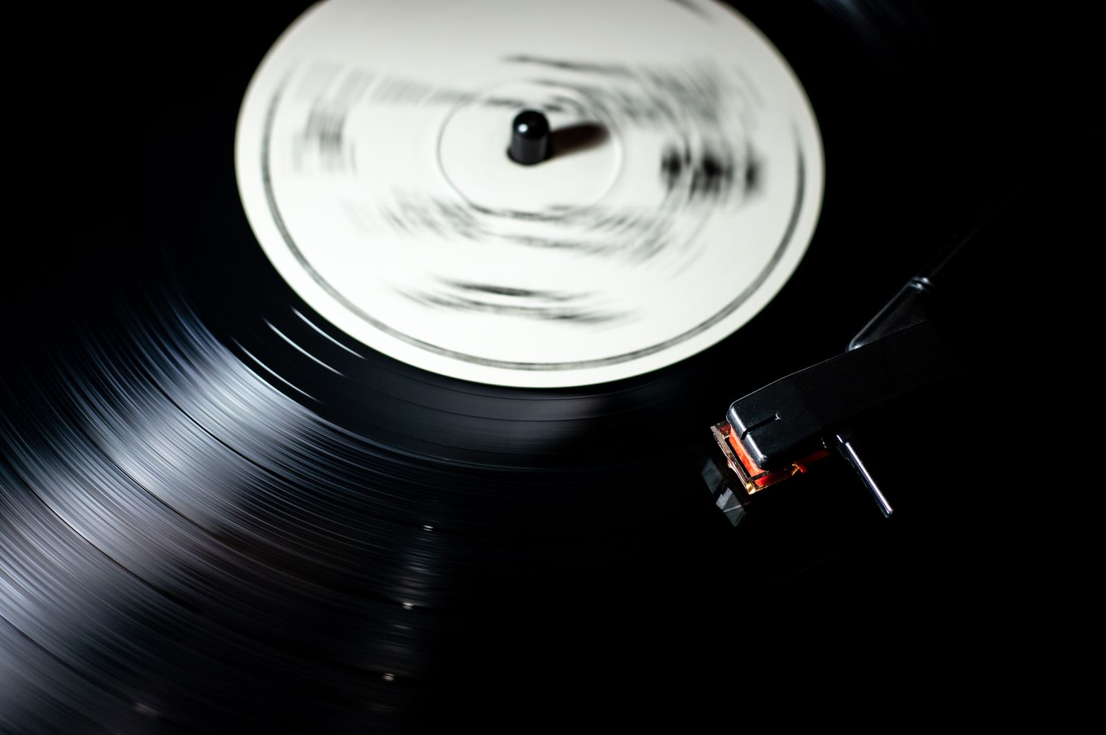 A vinyl record with a plain white label spinning on a turntable