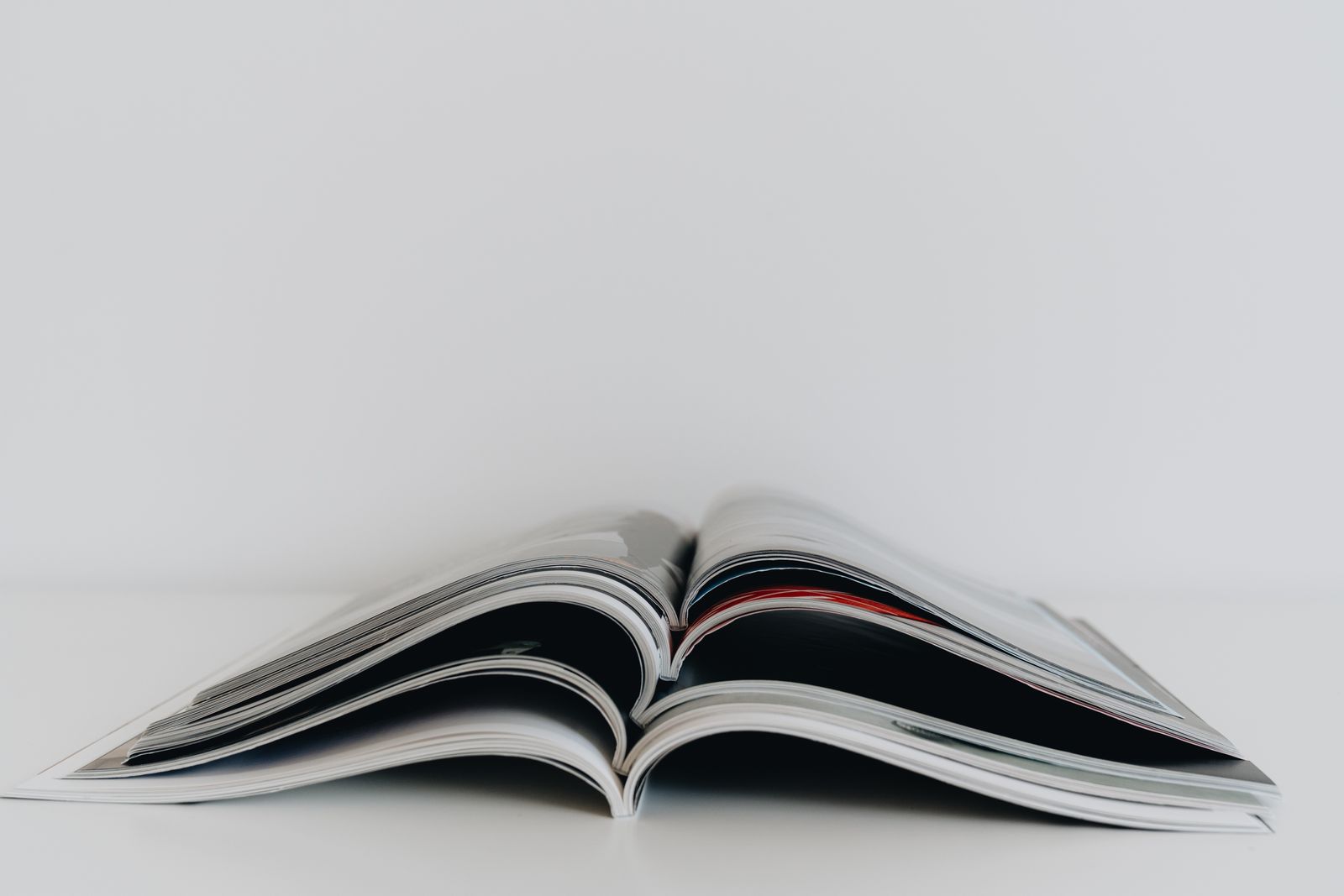 An open printed magazine lying on a white table