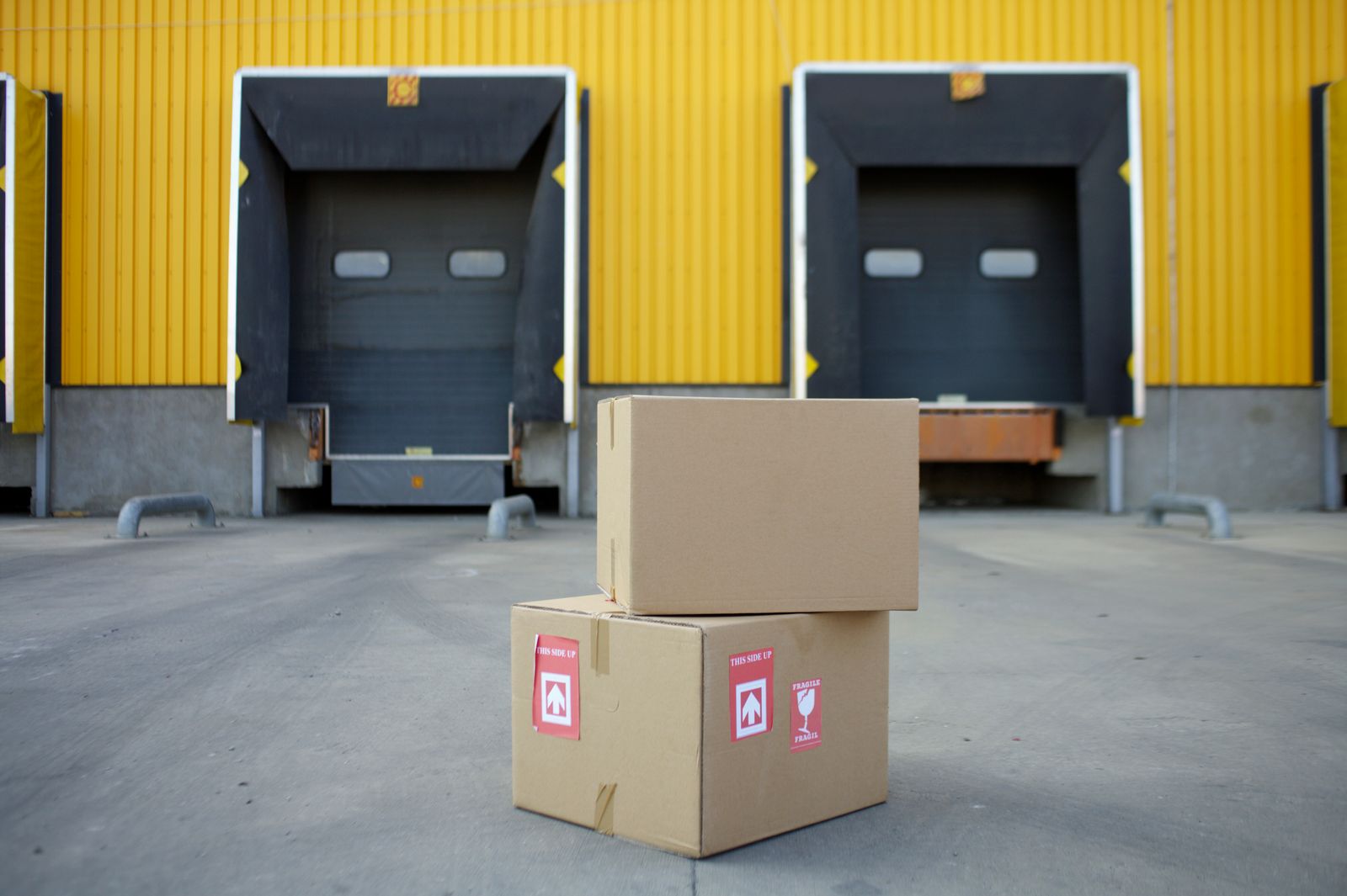 Cardboard boxes of equipment in front of two loading bay doors