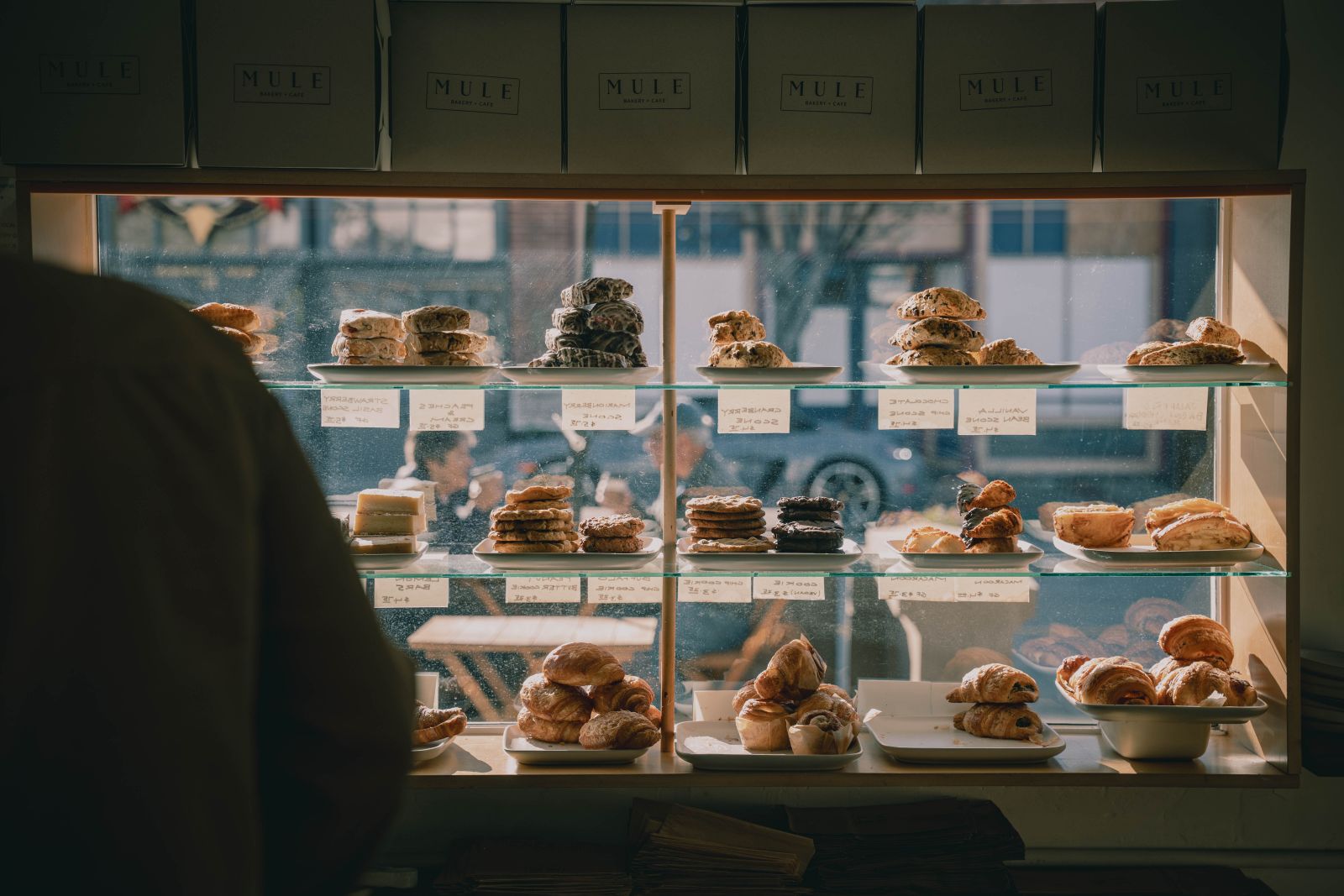 A bakery counter with shelves of bread and pastries in the early morning