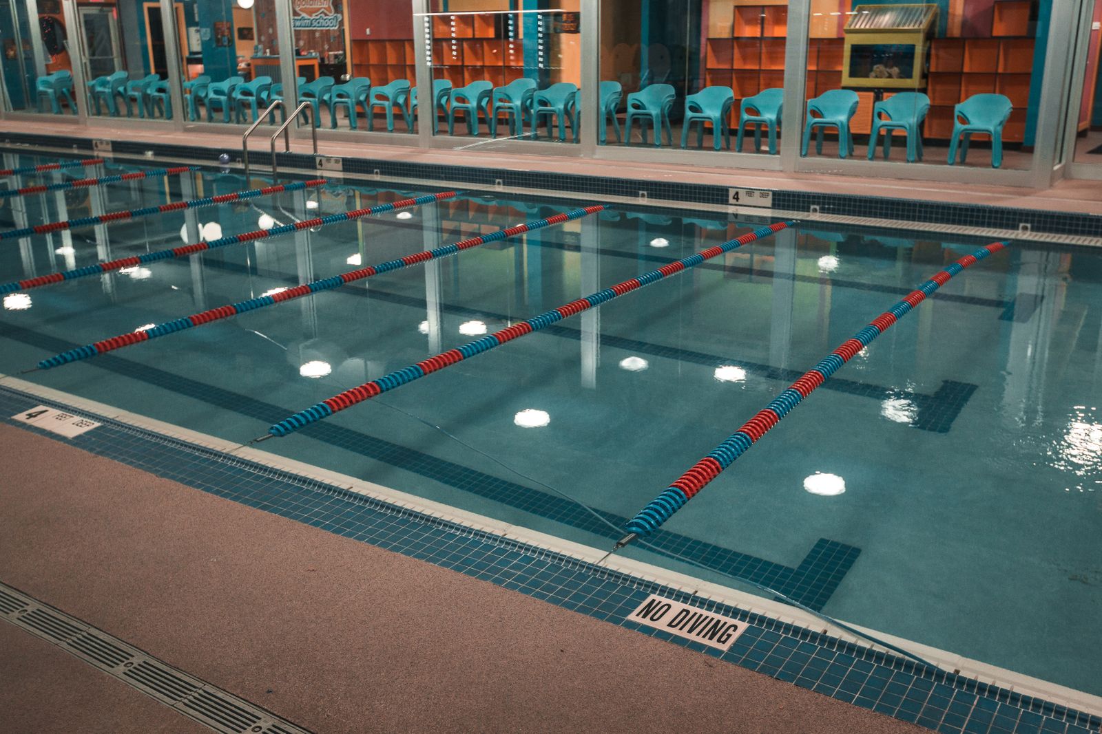 Empty indoor pool with lane markings on the floor