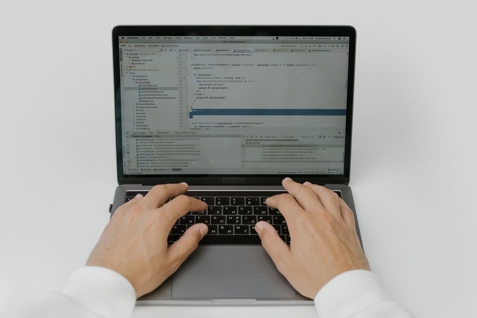 Hands typing code on a laptop