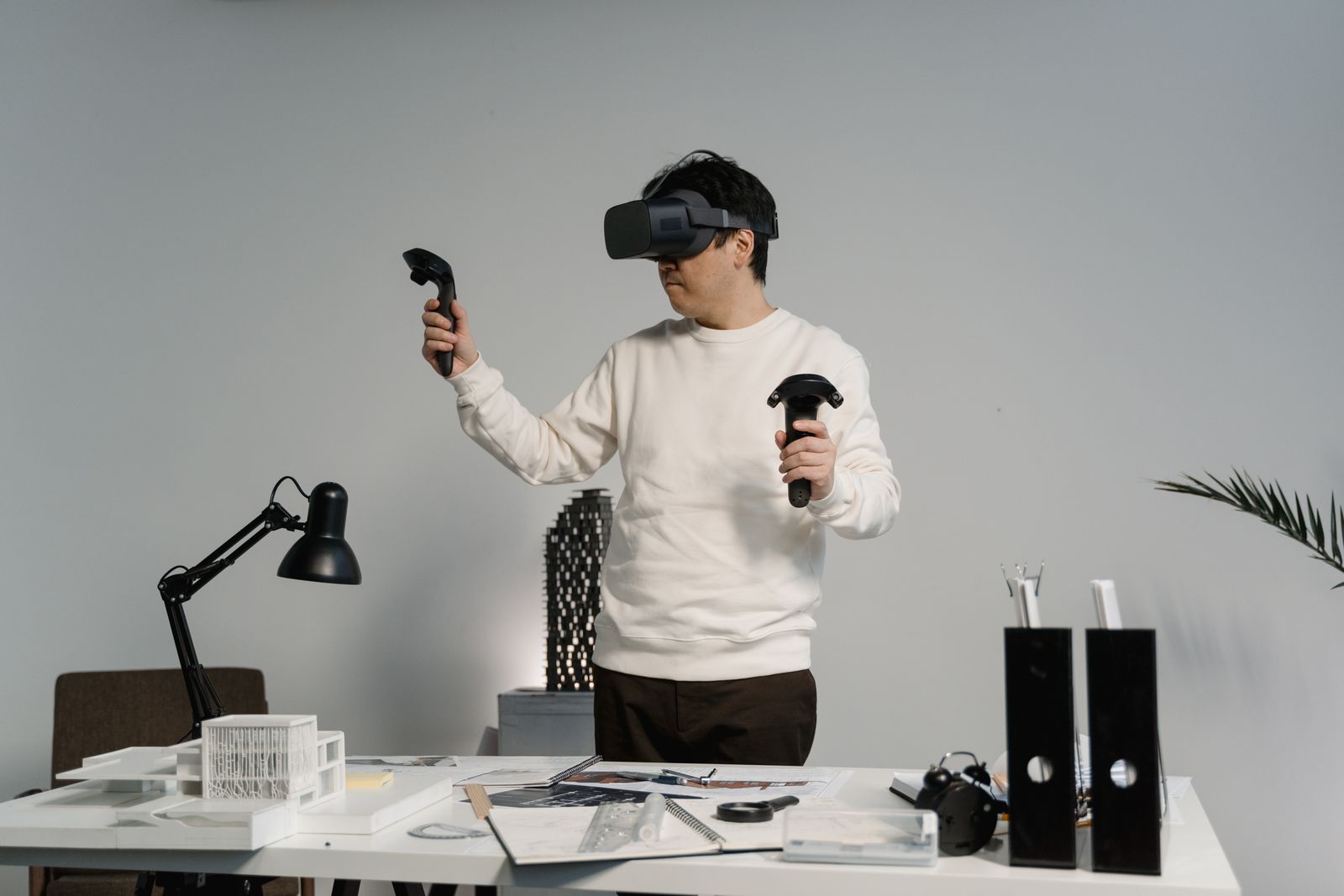 A developer testing a VR build with two controllers in a white studio room