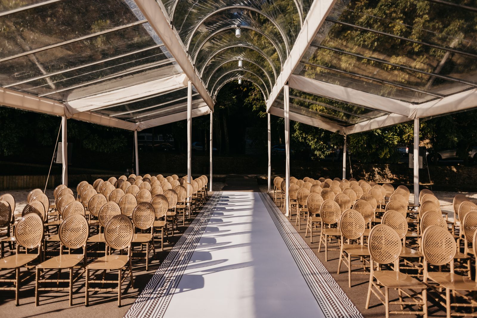 Chairs set in rows under a clear canopy for a ceremony