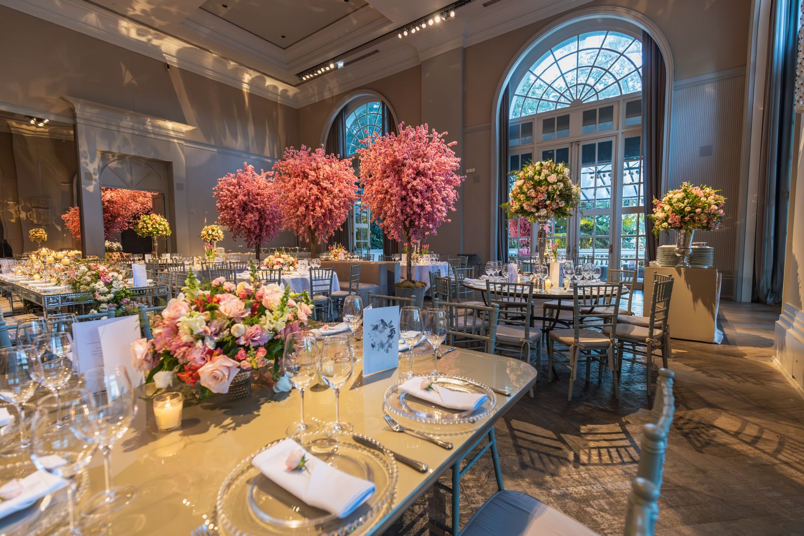 Tables with tall flower arrangements in a reception hall