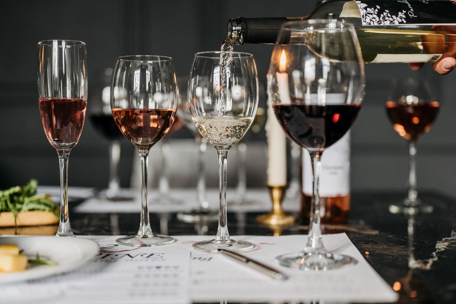 A tasting set with several glasses of red, white and rosé wine and a sheet of notes