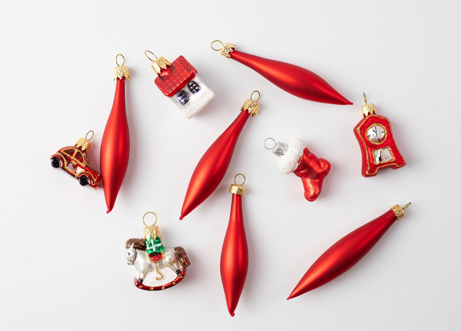 Red glass Christmas ornaments laid out on a white table